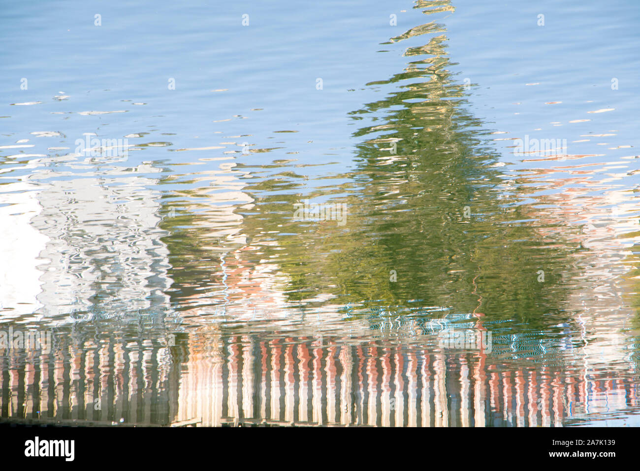 Réflexions floues d'arbres sur la surface du fleuve sur une journée ensoleillée Banque D'Images