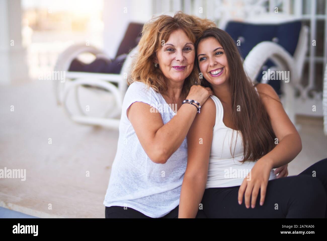 Belle Mère et fille assis à terrasse hugging and smiling Banque D'Images
