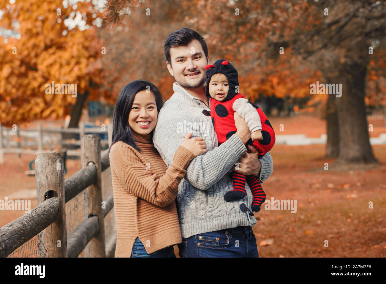 Chinois Asiatique Et Caucasienne Mere Pere Papa Avec Bebe Fille En Costume De Coccinelle Famille En Automne Automne Park Outdoor Avec De L Orange Jaune Les Feuilles Des Arbres Ha Photo Stock Alamy