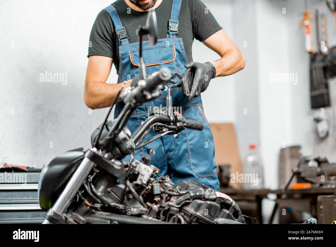 En salopette de mécanicien moto, réparation Porte-rétroviseur de mesure  pour le remplacement ou la mise au point à l'atelier à l'intérieur Photo  Stock - Alamy