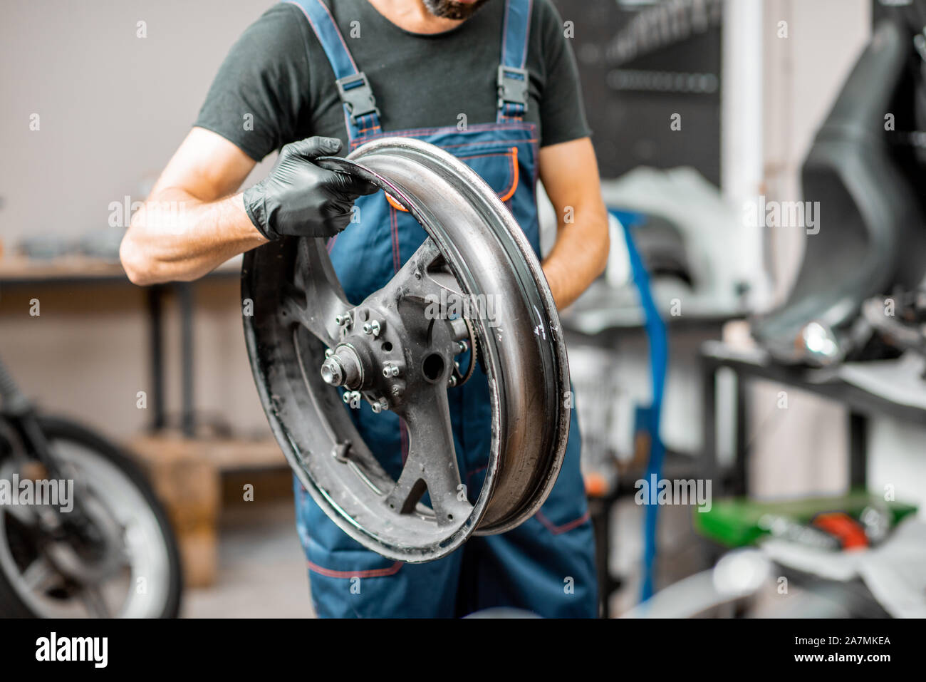 En travaillant dur, moto tenue salopette changer les pneus à l'atelier de réparation de moto Banque D'Images