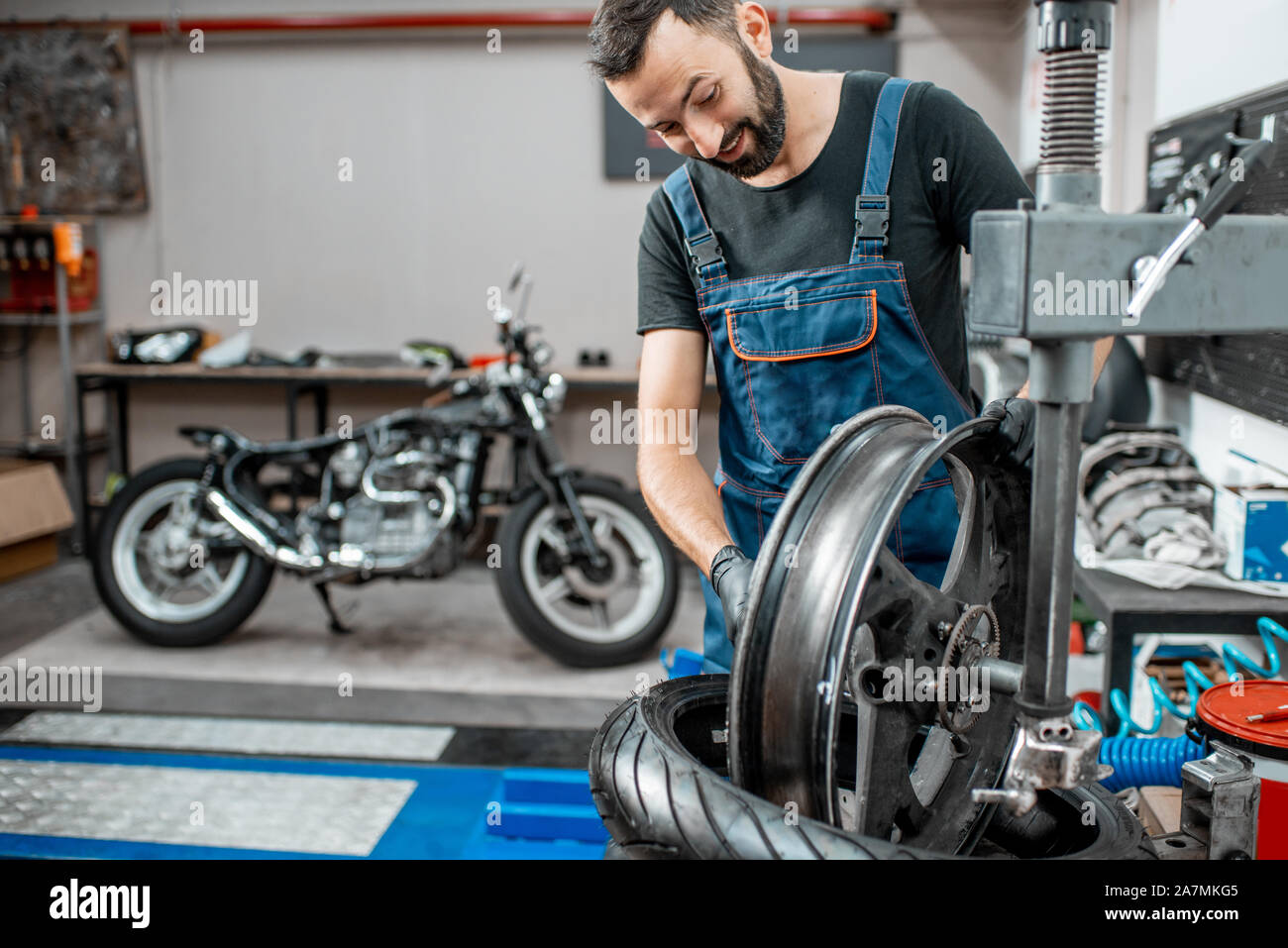 L'évolution des techniques de travail sur pneu moto un équipement spécial pour l'installation de pneus à l'atelier de réparation de moto Banque D'Images