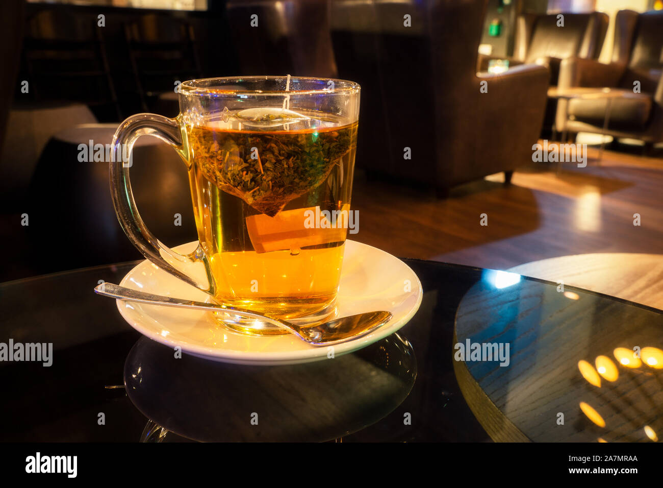 La tisane infuser dans une tasse en verre sur une table en verre de nuit avec copie espace. Banque D'Images
