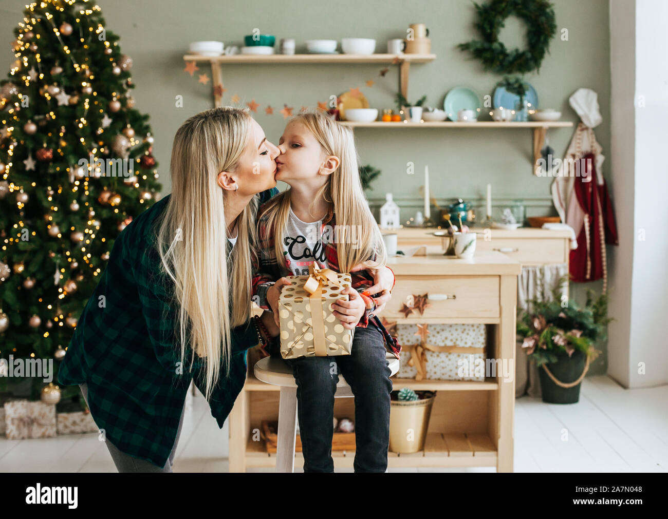 Portrait de Mère et fille en prévision de Noël. Maman embrasse sa fille et donne un don Banque D'Images