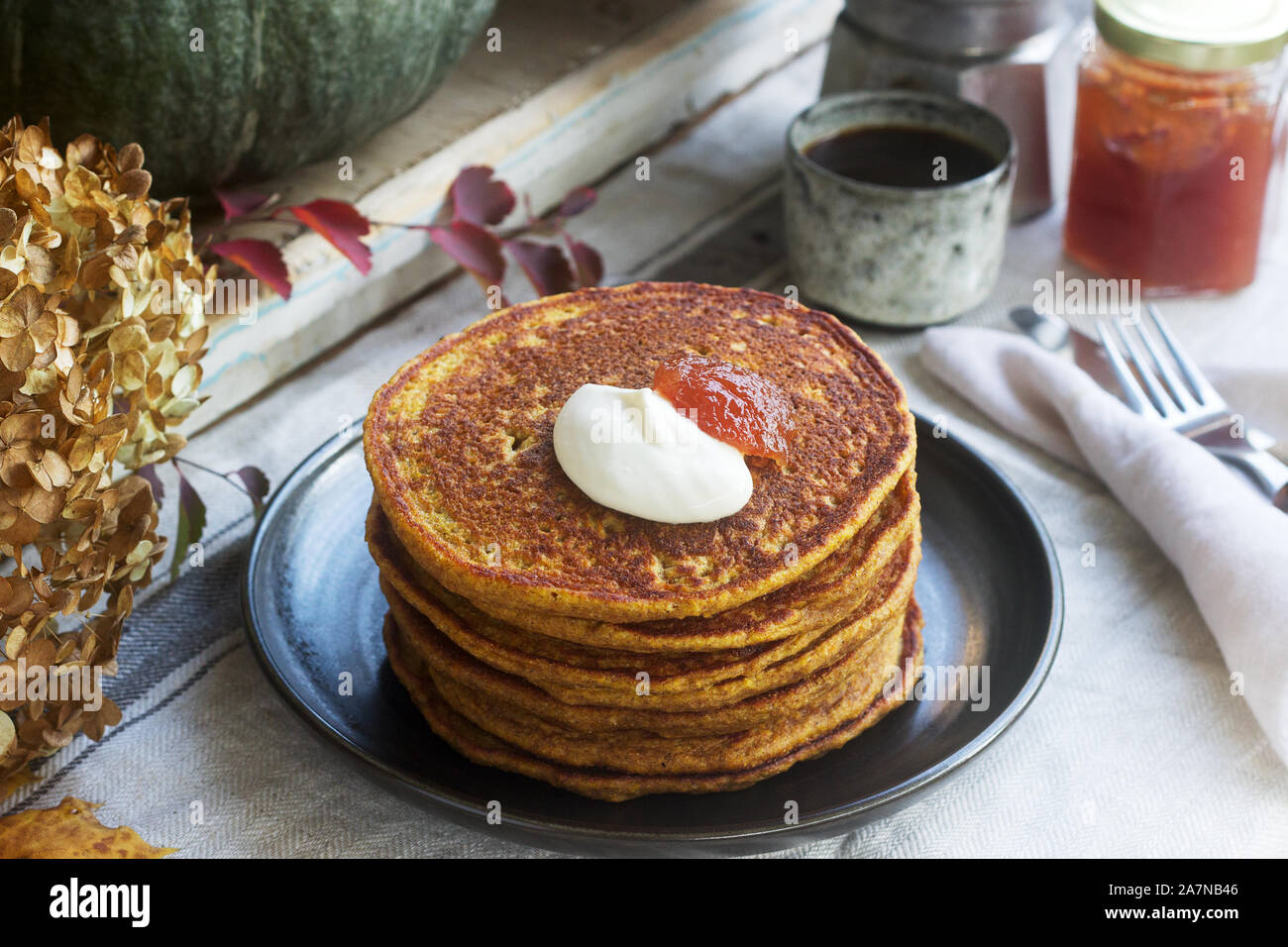 Crêpes à la citrouille avec crème et de la confiture sur un fond d'automne de la vie encore. Banque D'Images