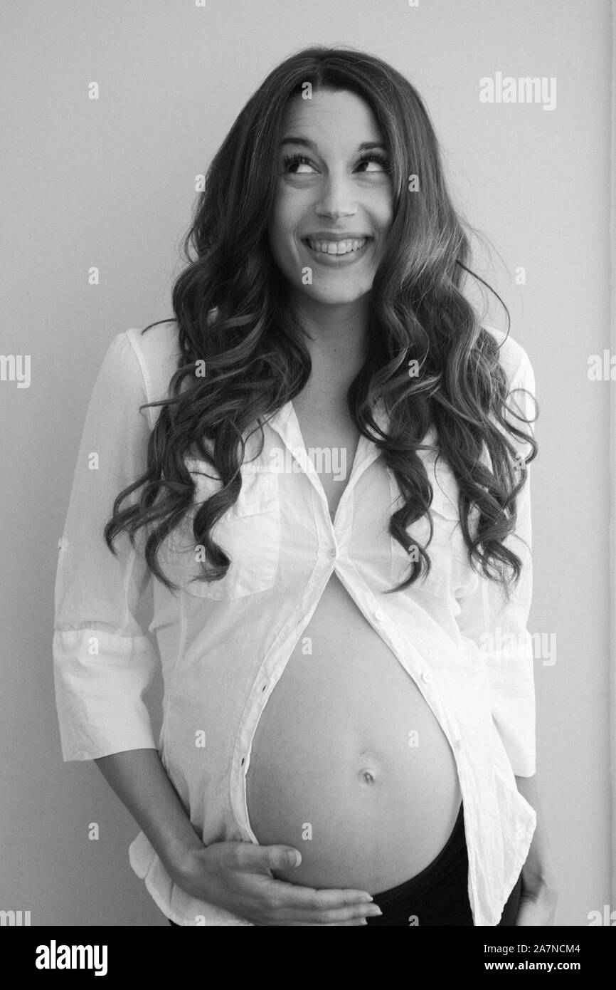 Femme enceinte en noir et blanc en chemise blanche Banque D'Images