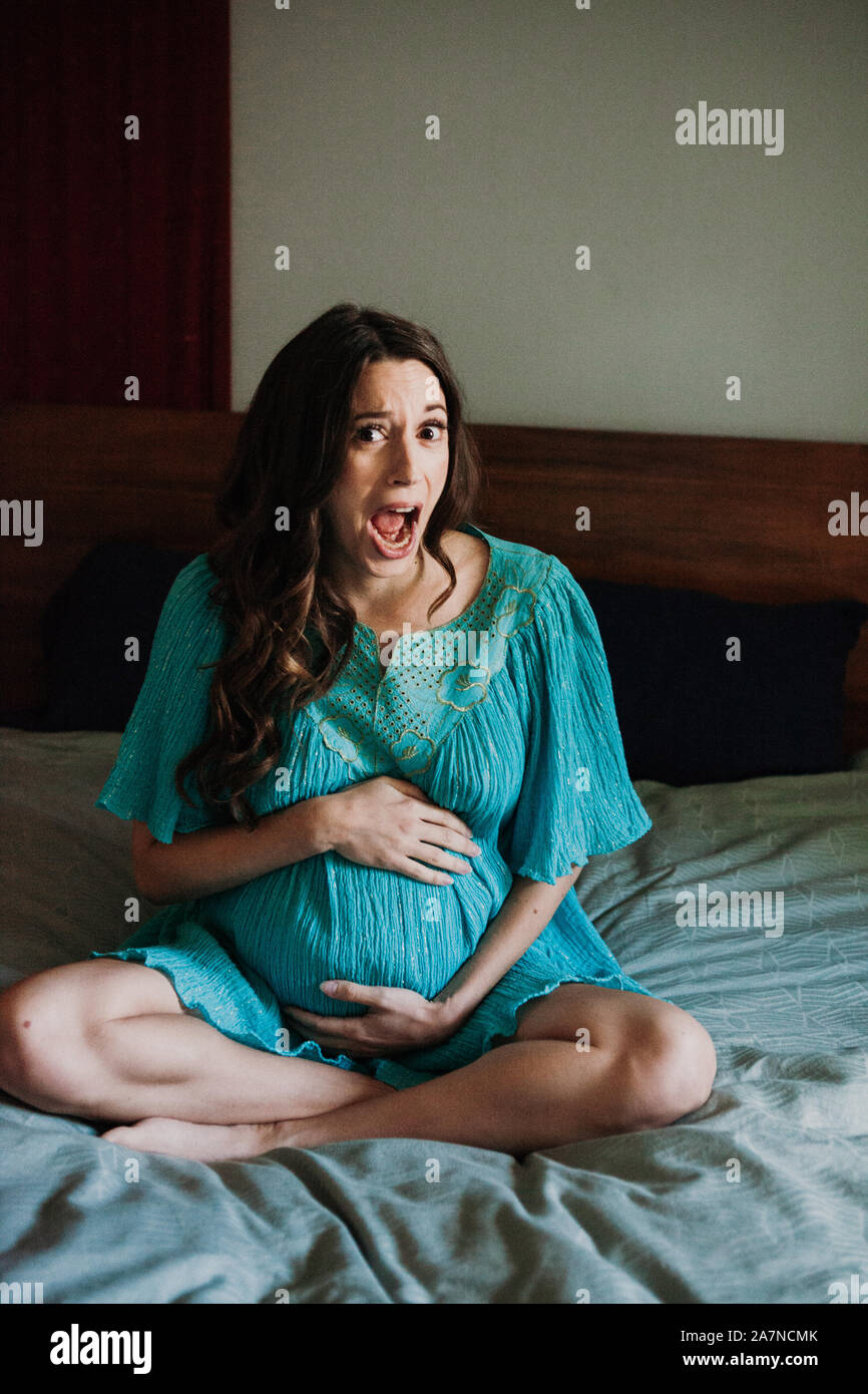 Femme enceinte au lit drôle de visage Banque D'Images