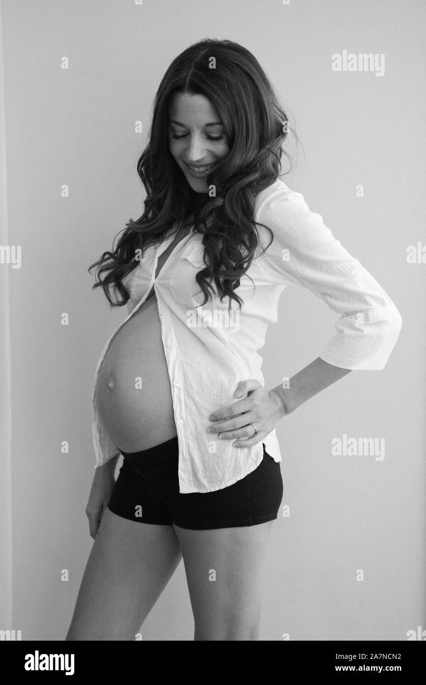 Pregnant woman smiling black and white Banque D'Images