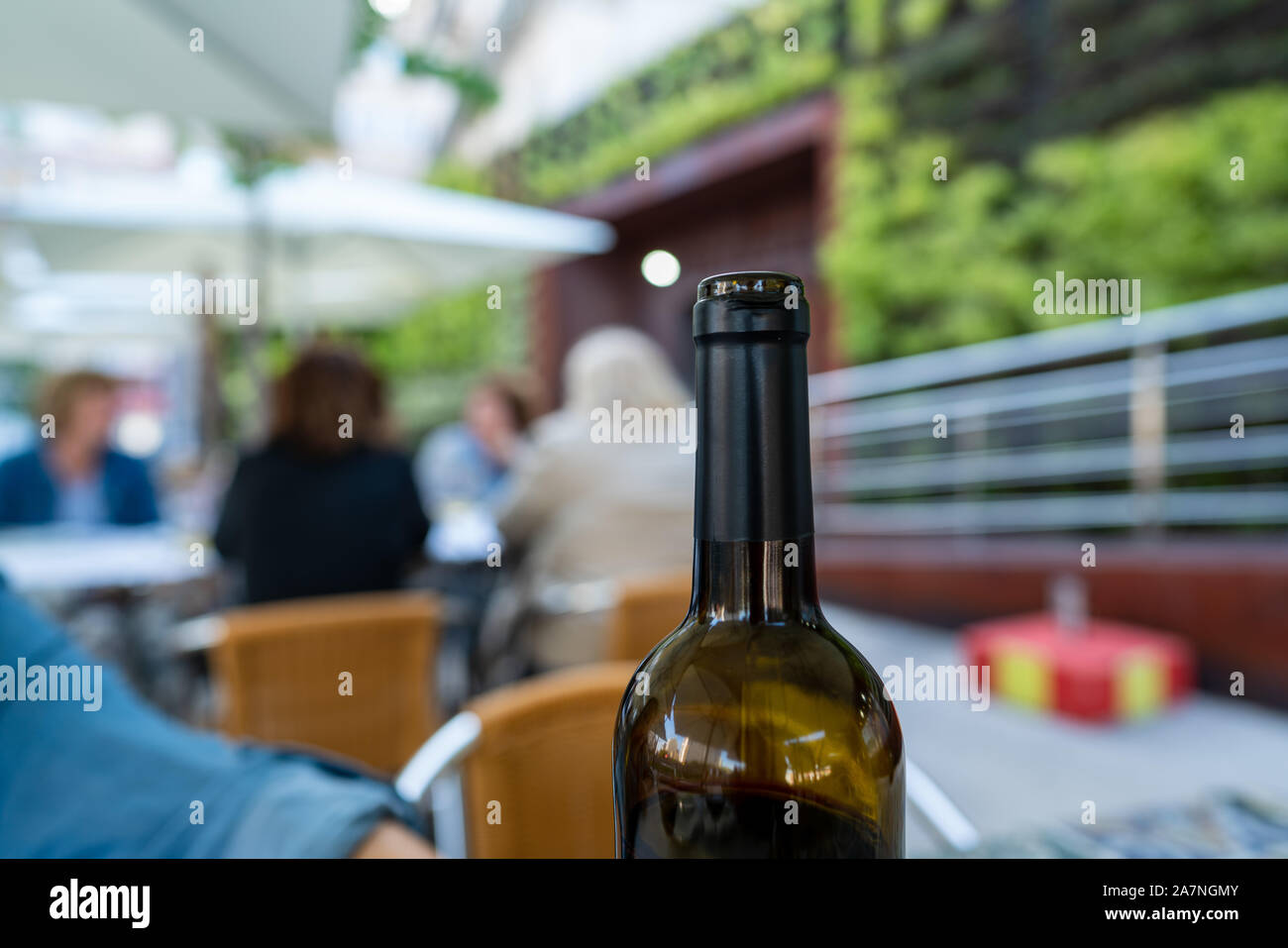 Ouvrir bouteille de vin rouge à un restaurant en plein air avec des clients Banque D'Images