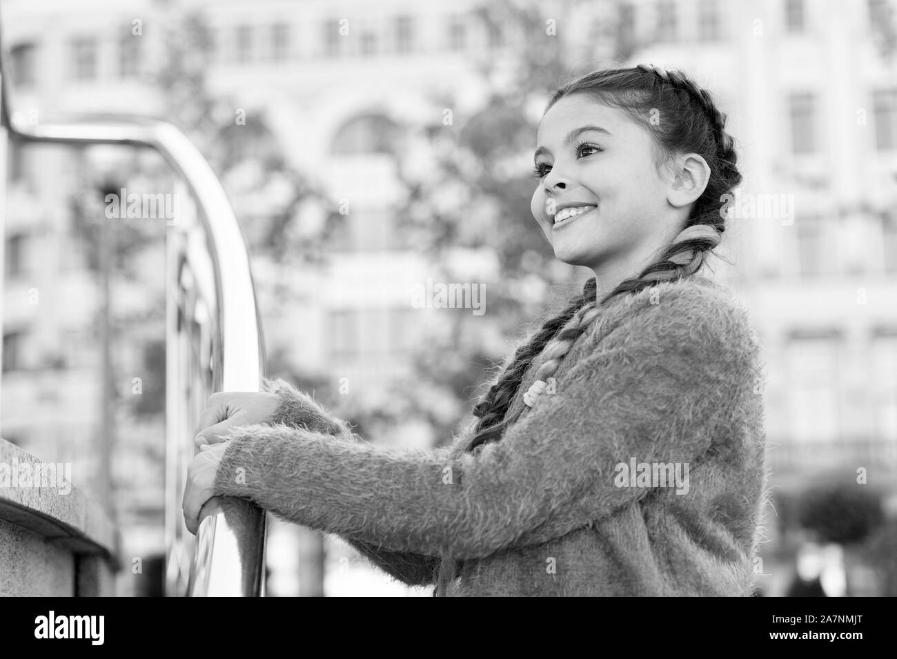 Un séjour magnifique. Petit enfant avec fashion look. Petit garçon avec des cheveux brun en souriant style décontracté. Adorable gamin au sourire mignon sur journée d'été. Happy girl kid sur l'extérieur en milieu urbain. Banque D'Images