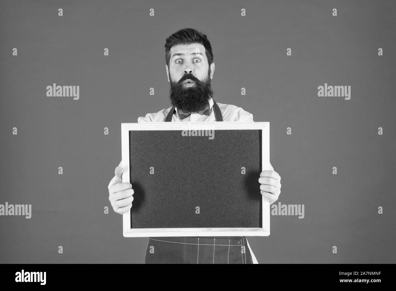 Les Happy hours. Café shop la publicité. Hipster barbu homme en tablier. Chef avec tableau noir de l'espace de copie. Espace publicitaire. Vente de magasin. Le vendredi noir commode. Concept de publicité. Repas de cuisine par recette. Banque D'Images