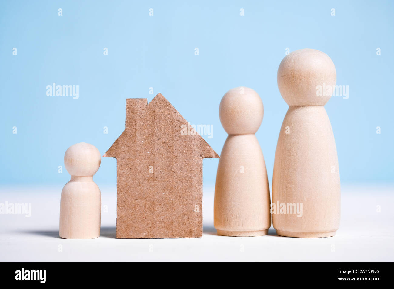 Abstract maison en carton près de la famille : maman, papa, bébé. Accueil Concept de propriété collective. Close up. Banque D'Images