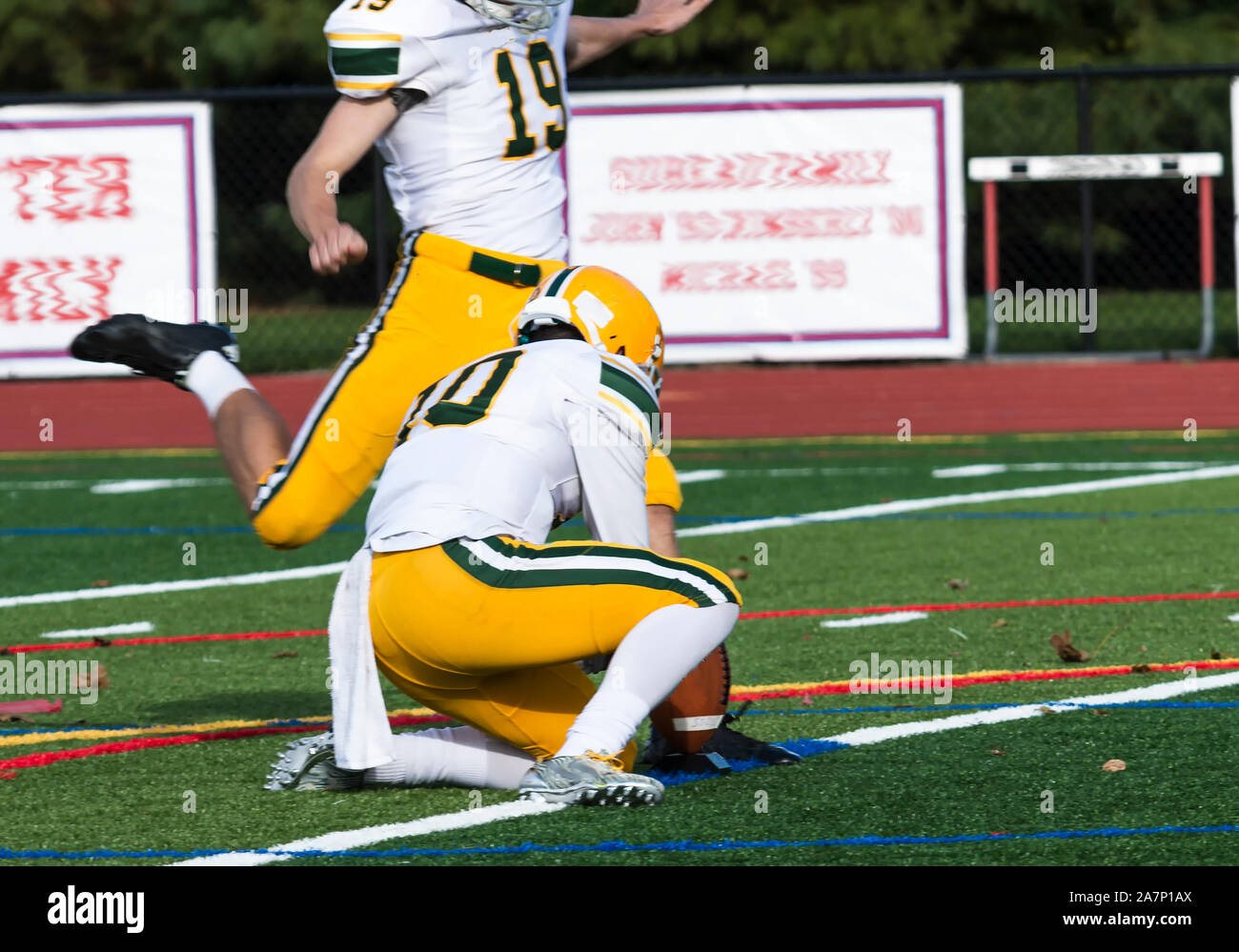 Un objectif sur le terrain avec l'or de kick pants, des coups de la balle lors d'un match de football de l'école secondaire Banque D'Images