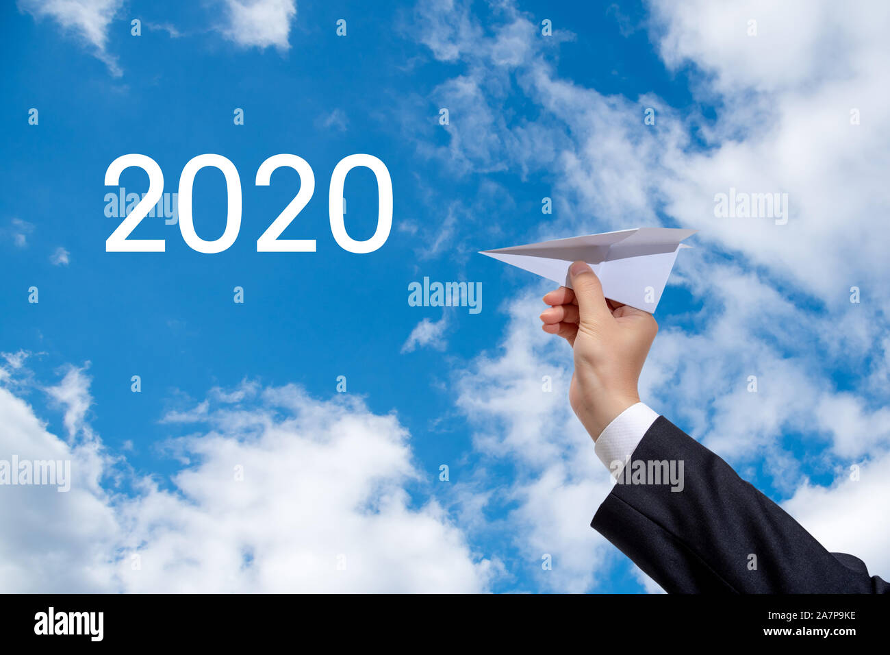Businessman's hand voler un avion en papier à l'horizon 2020. Banque D'Images