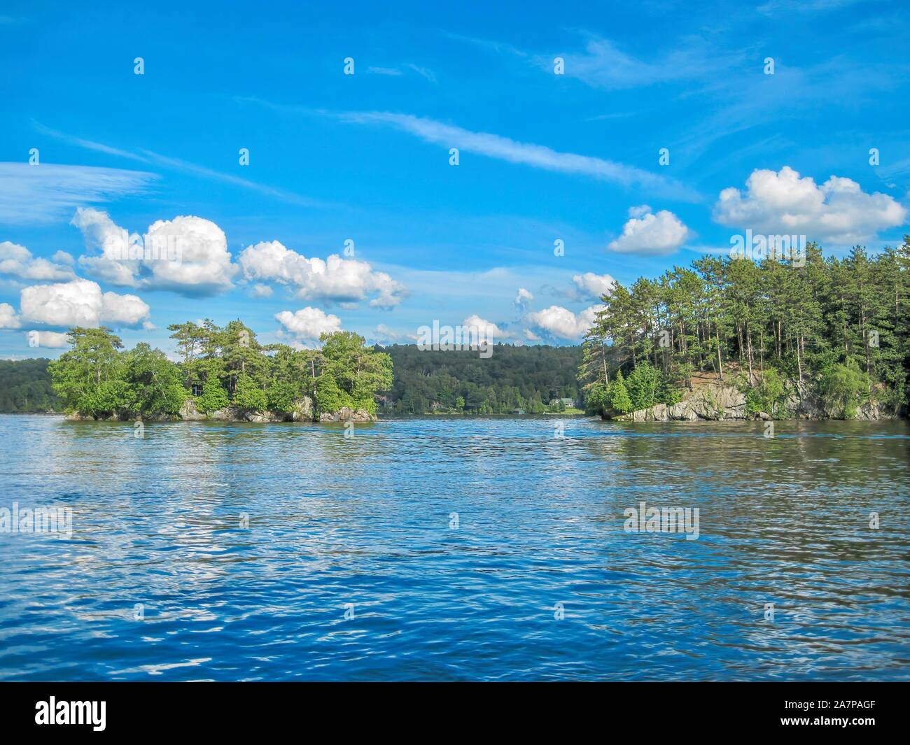 Une journée ensoleillée sur un lac en été, avec une vue du bateau de deux îles boisées. Lac Memphrémagog, Québec. Banque D'Images