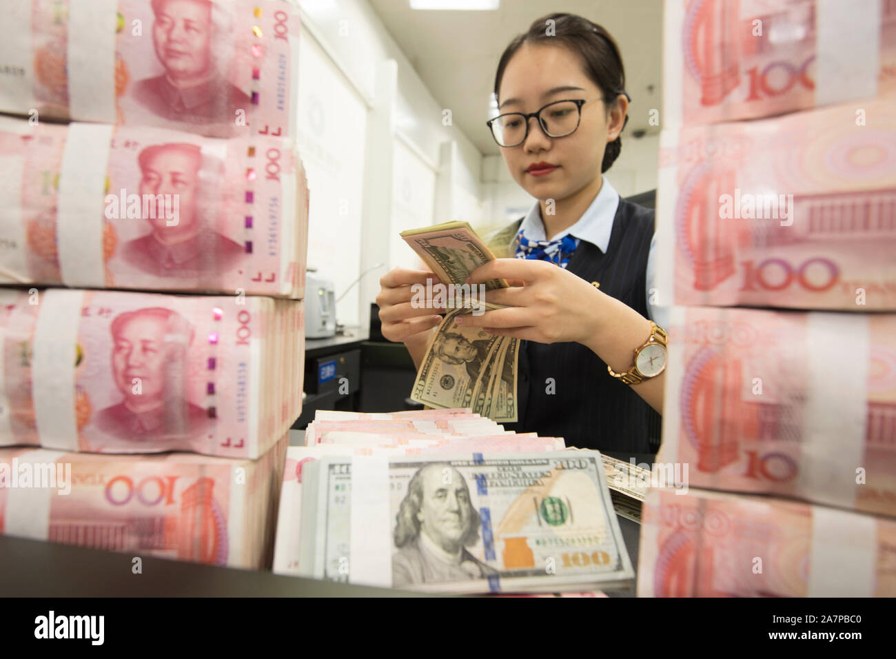Un greffier chinois compte US dollar note plus de RMB yuan (renminbi) notes à une banque à Hai'an city, Nantong ville, province de Jiangsu Chine orientale, 6 août Banque D'Images