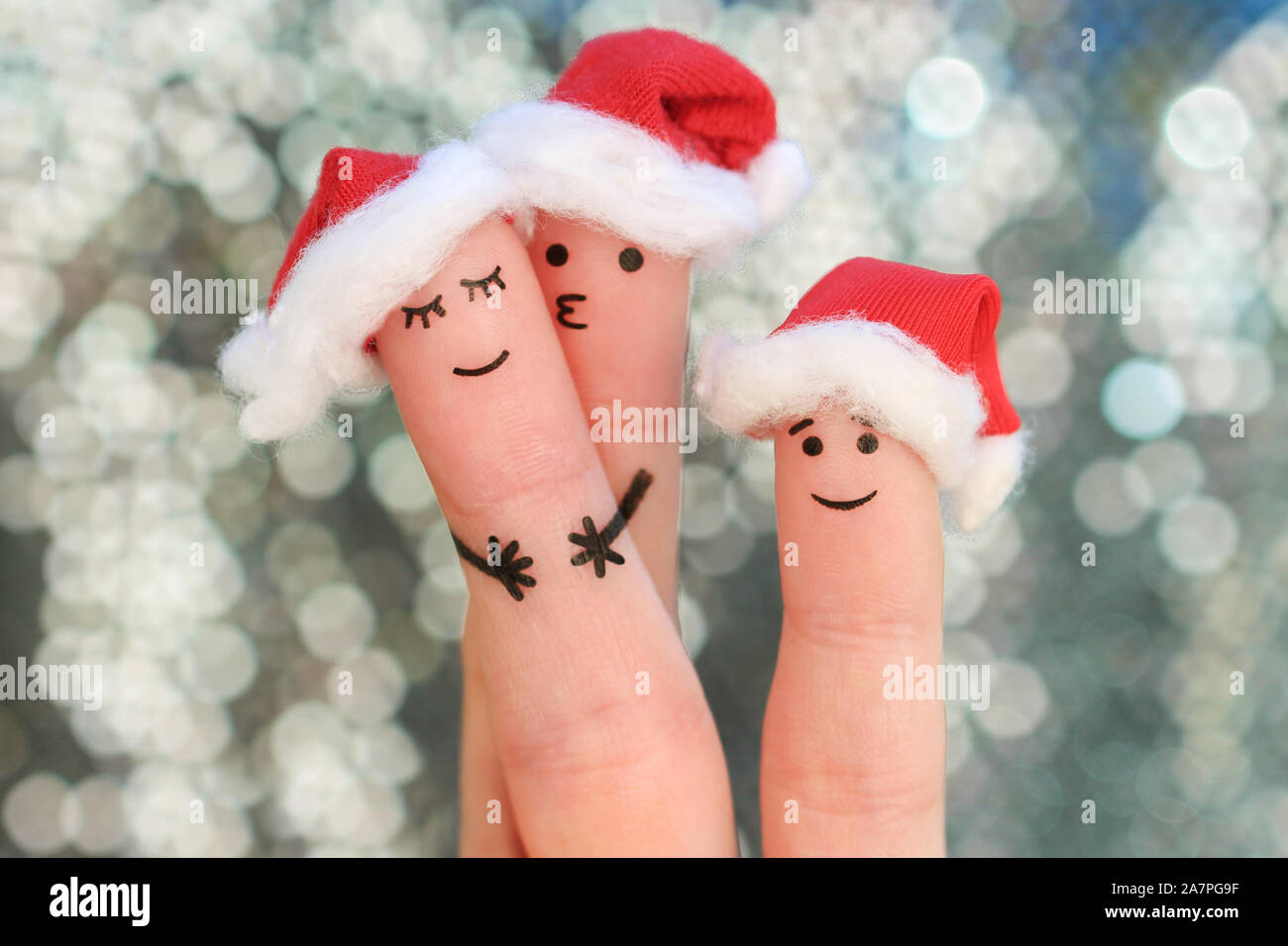 Doigts art de la famille célèbre Noël. Notion de groupe de personnes souriantes dans nouvelle année chapeaux. Banque D'Images