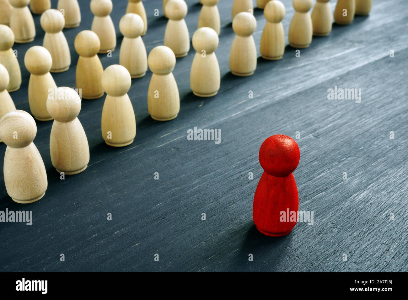 Concept de gestion du leadership. La figure Rouge comme chef en face de figures en bois. Banque D'Images