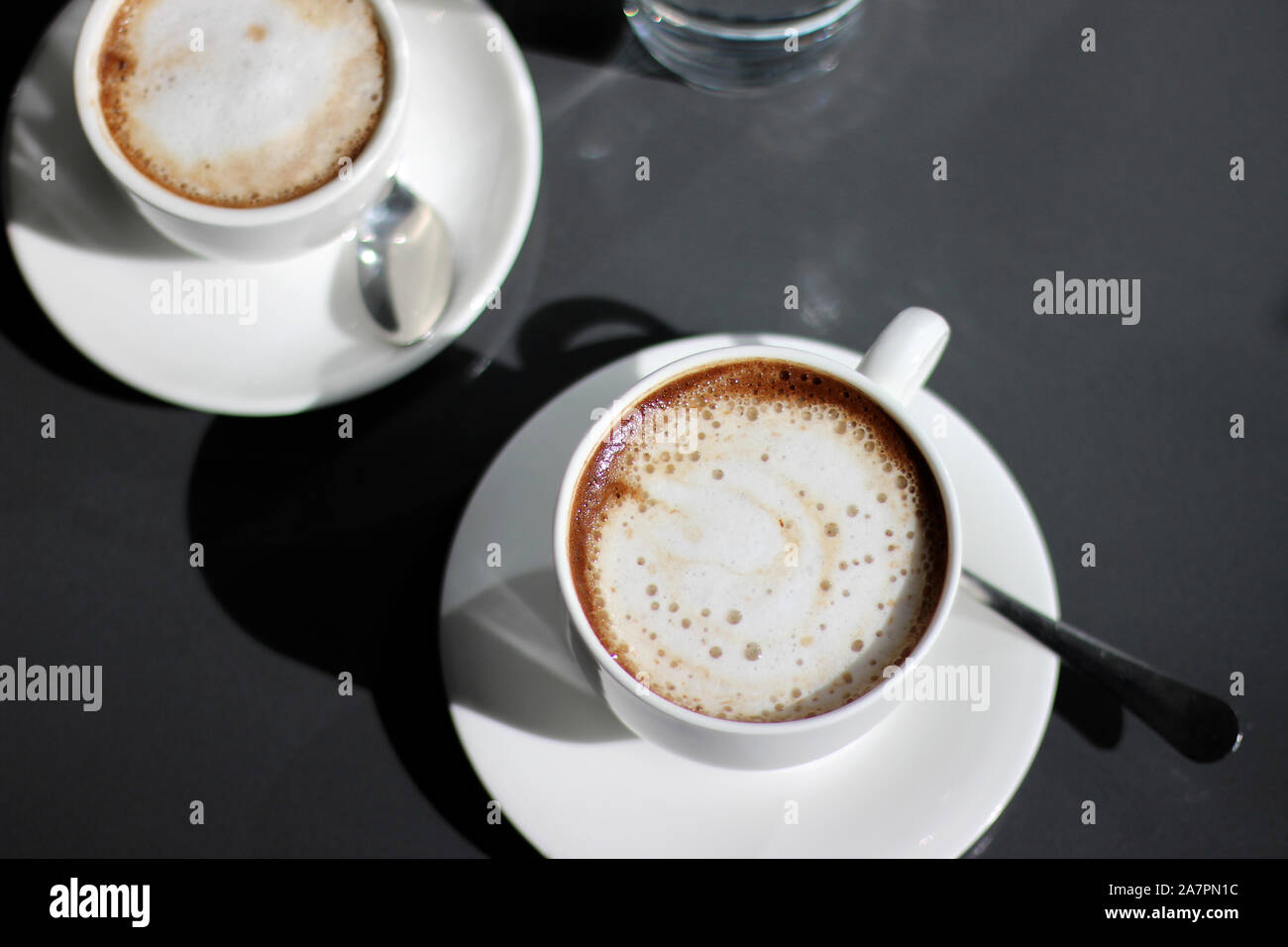 Cappuccino Fraîchement Préparé Dans Les Tasses De Demitasse. Vue en hauteur du café sur le fond sombre. Banque D'Images
