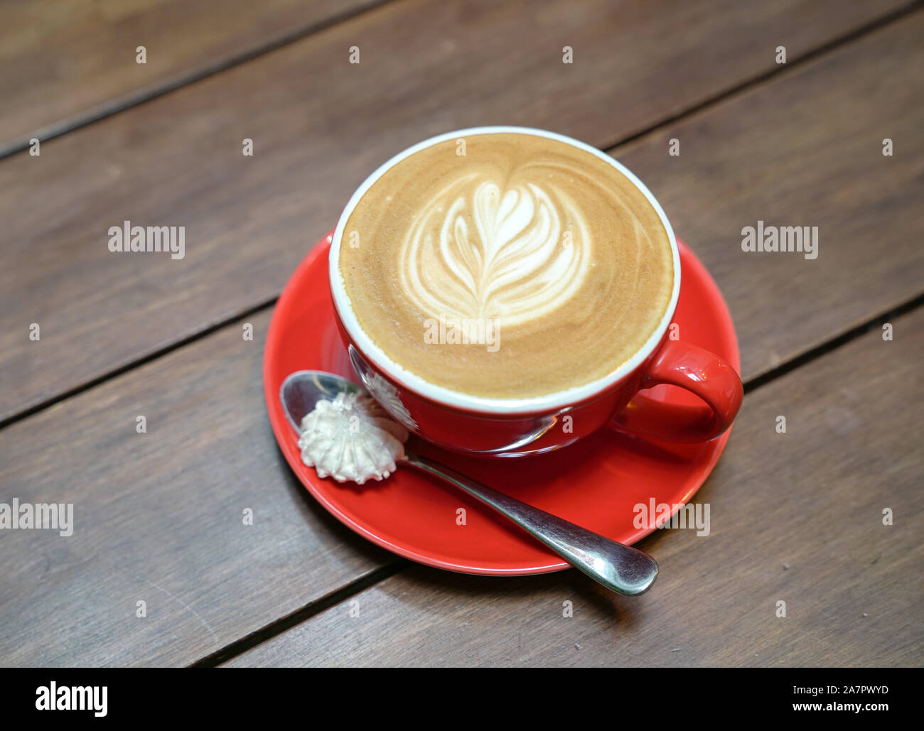 Télévision avec café blanc motif coeur rouge dans une tasse sur la table en bois Banque D'Images