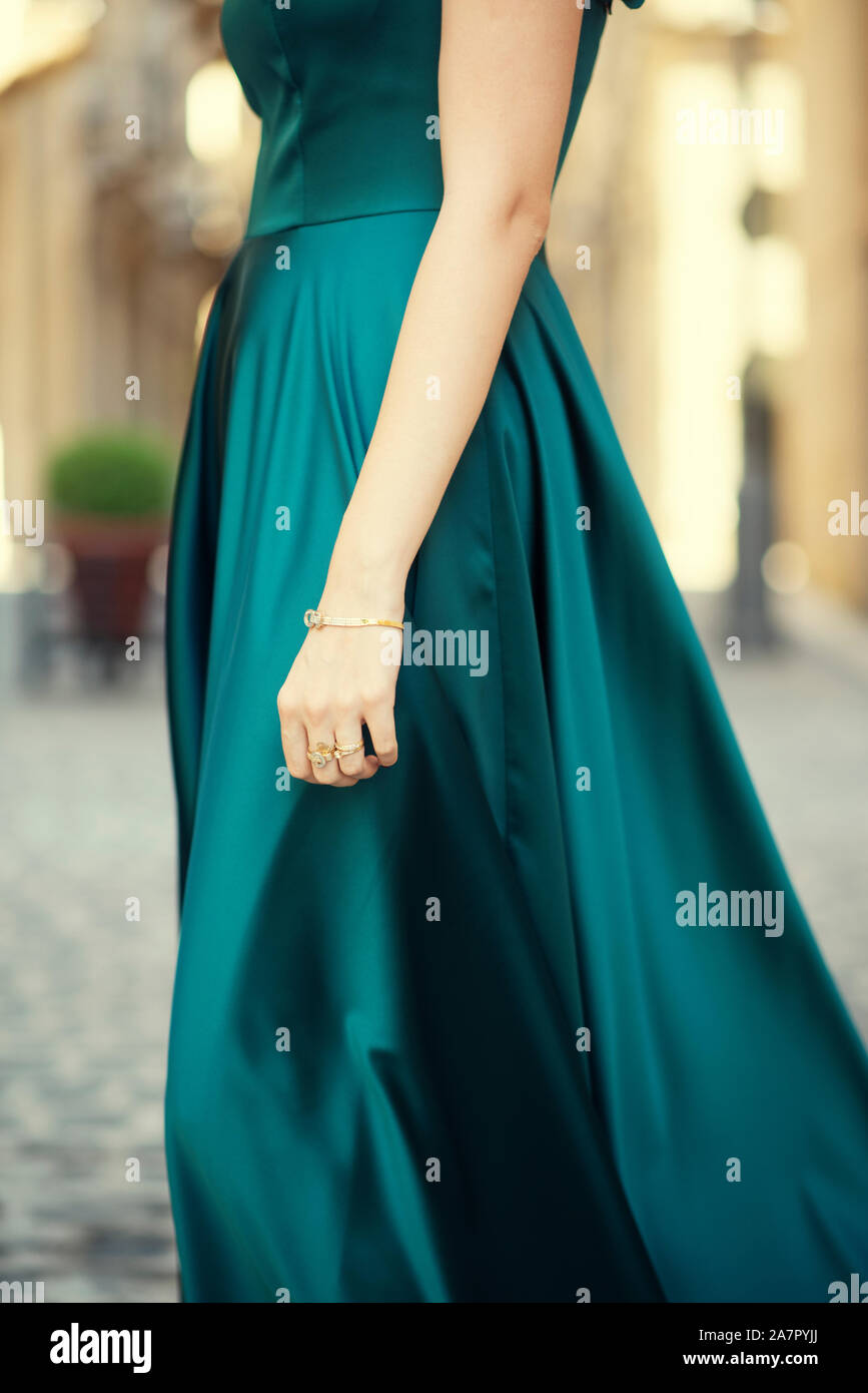 Side view close up une femme en robe de soirée verte standing outdoors Banque D'Images