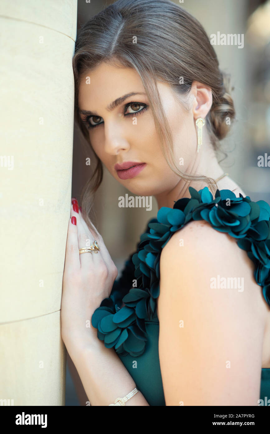 Beautiful woman leaning against wall outdoors Banque D'Images