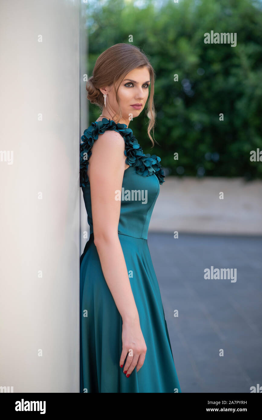 Beautiful woman leaning against wall outdoors Banque D'Images
