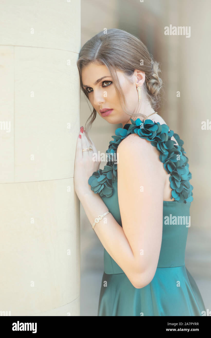 Beautiful woman leaning against wall outdoors Banque D'Images