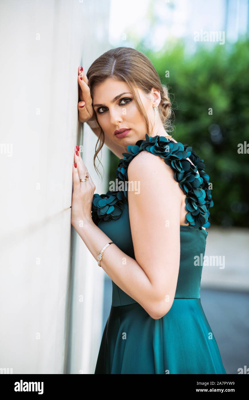 Beautiful woman leaning against wall outdoors Banque D'Images