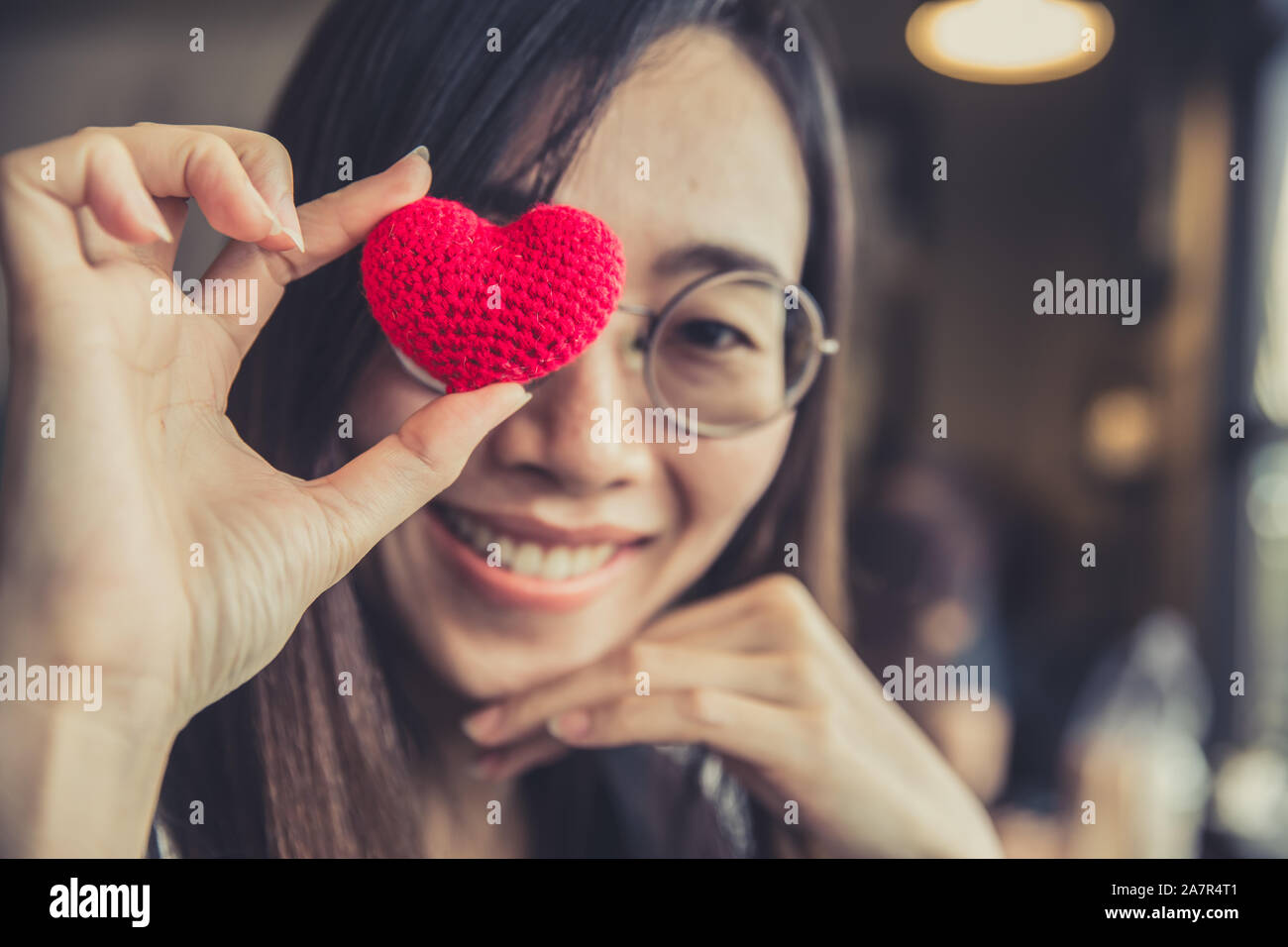 Les femmes lunettes main tenant coeur d'amour et de soins des yeux de votre concept. Banque D'Images