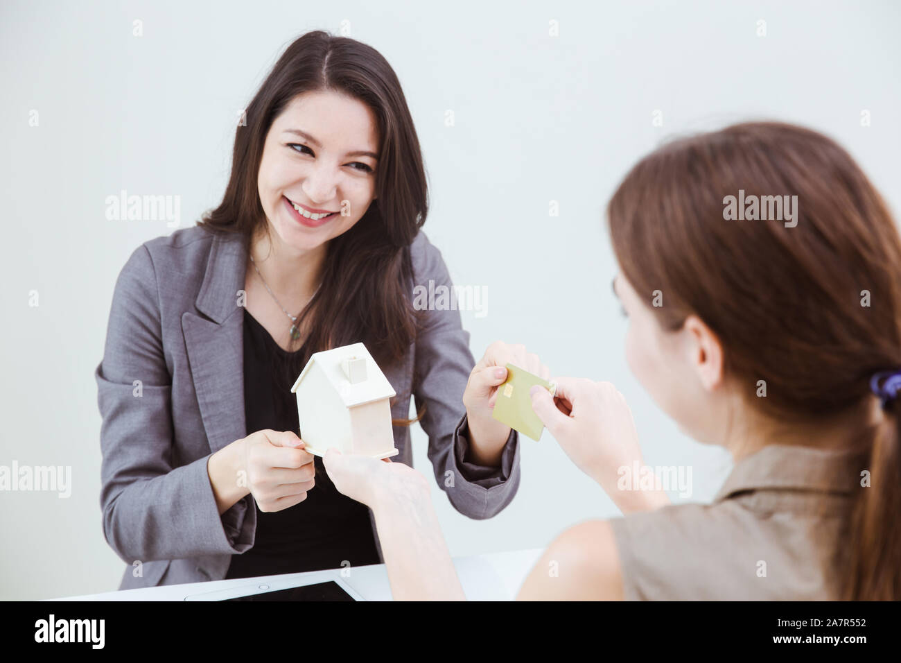 Client à l'aide d'une carte de crédit pour acheter une nouvelle maison avec l'agence house sourire heureux. Banque D'Images