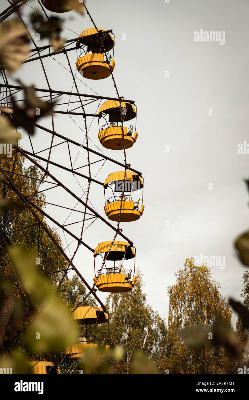 Célèbre roue dans le parc d'attractions abandonné dans la ville vide de Pripyat près du réacteur nucléaire de Tchernobyl au cours de l'automne (Kyiv, Ukraine, l'Europe) Banque D'Images