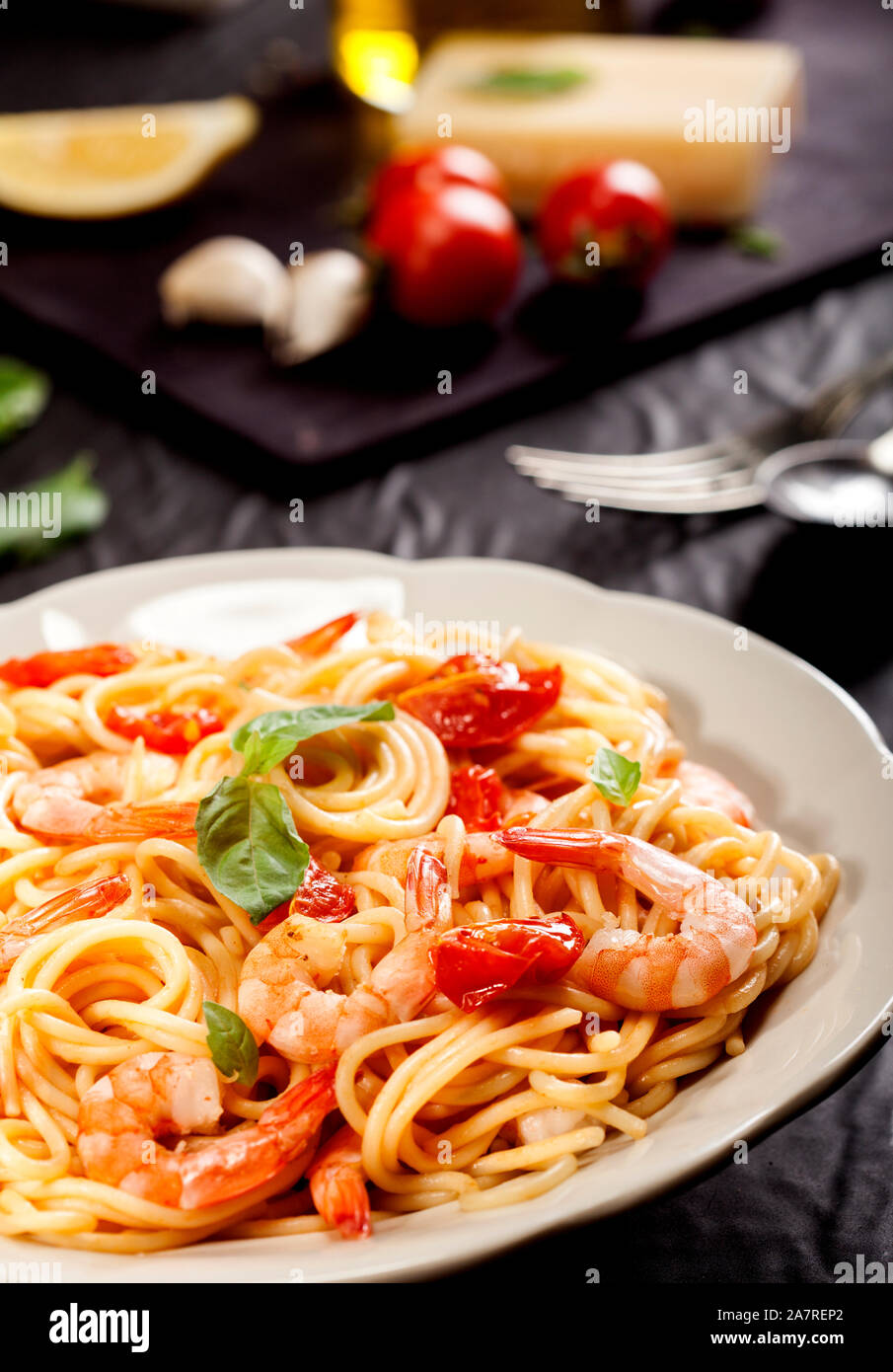 Spaghetti Pâtes aux crevettes, tomates séchées et basilic sur fond noir.  Repas sain. Cuisine italienne Photo Stock - Alamy