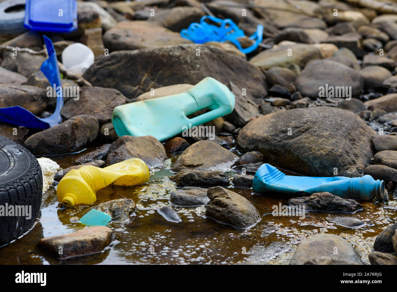 L'eau sale avec les déchets en plastique et des pneus des algues sur la côte de l'océan Banque D'Images
