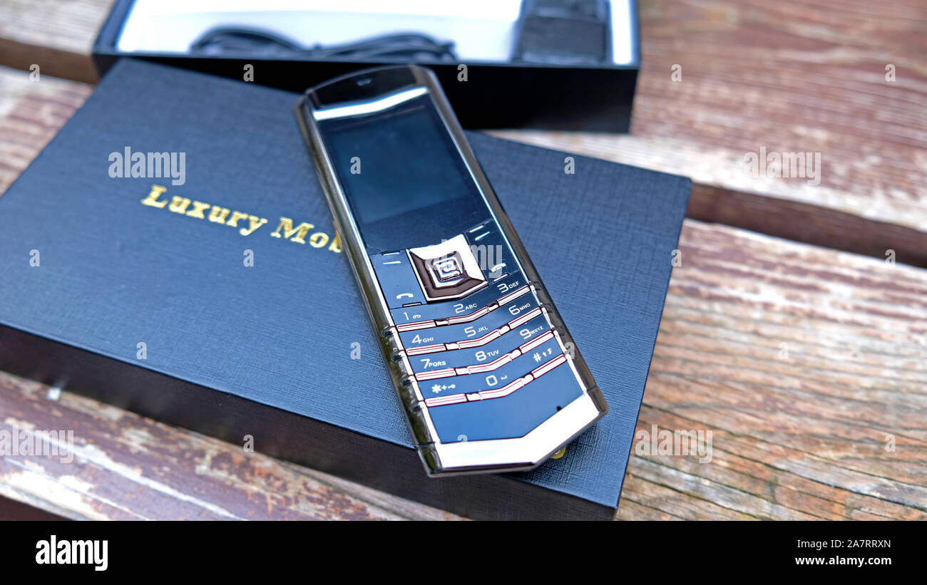 Téléphone de luxe noir sur le bois de chêne Banque D'Images