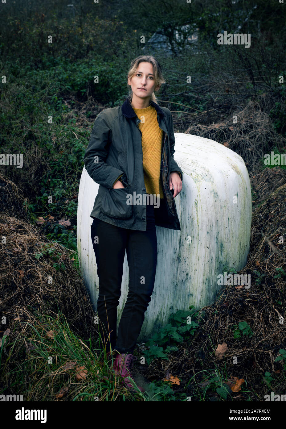 Portrait d'une femme blonde dans une forêt avec la main dans sa poche Banque D'Images