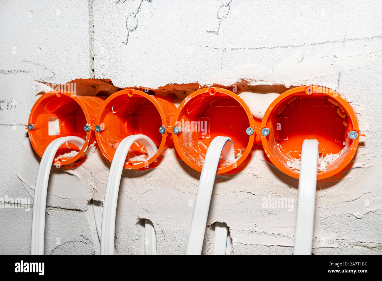 Boîte de jonction ronde Orange, monté dans le mur blanc avec les câbles électriques. Banque D'Images