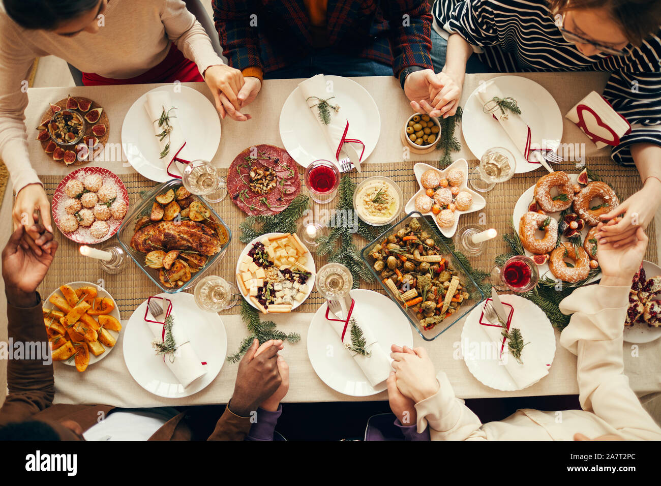 Voir ci-dessus au groupe de gens assis à table à manger à Noël et joindre les mains en prière, copy space Banque D'Images