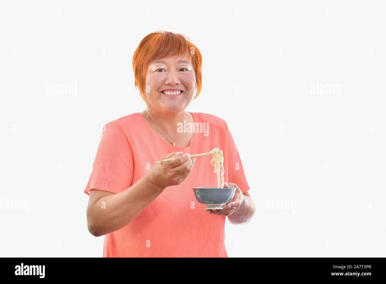 Chinese woman eating with chopsticks Banque D'Images