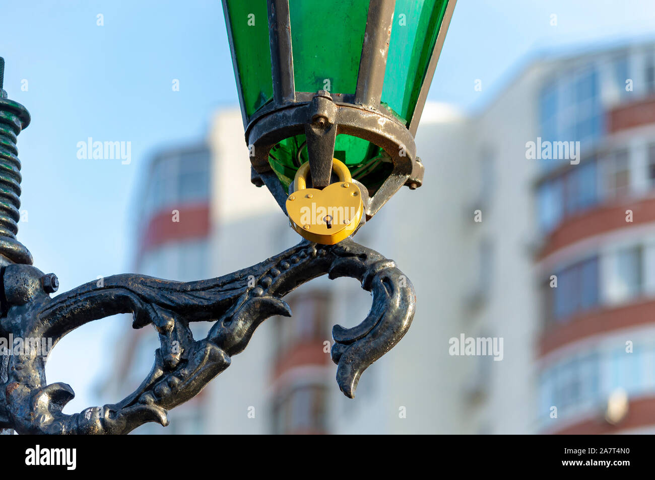 Cadenas en métal jaune sur le lampadaire en park en l'honneur de l'amour de jeune fille et garçon. Vue de dessous. Banque D'Images