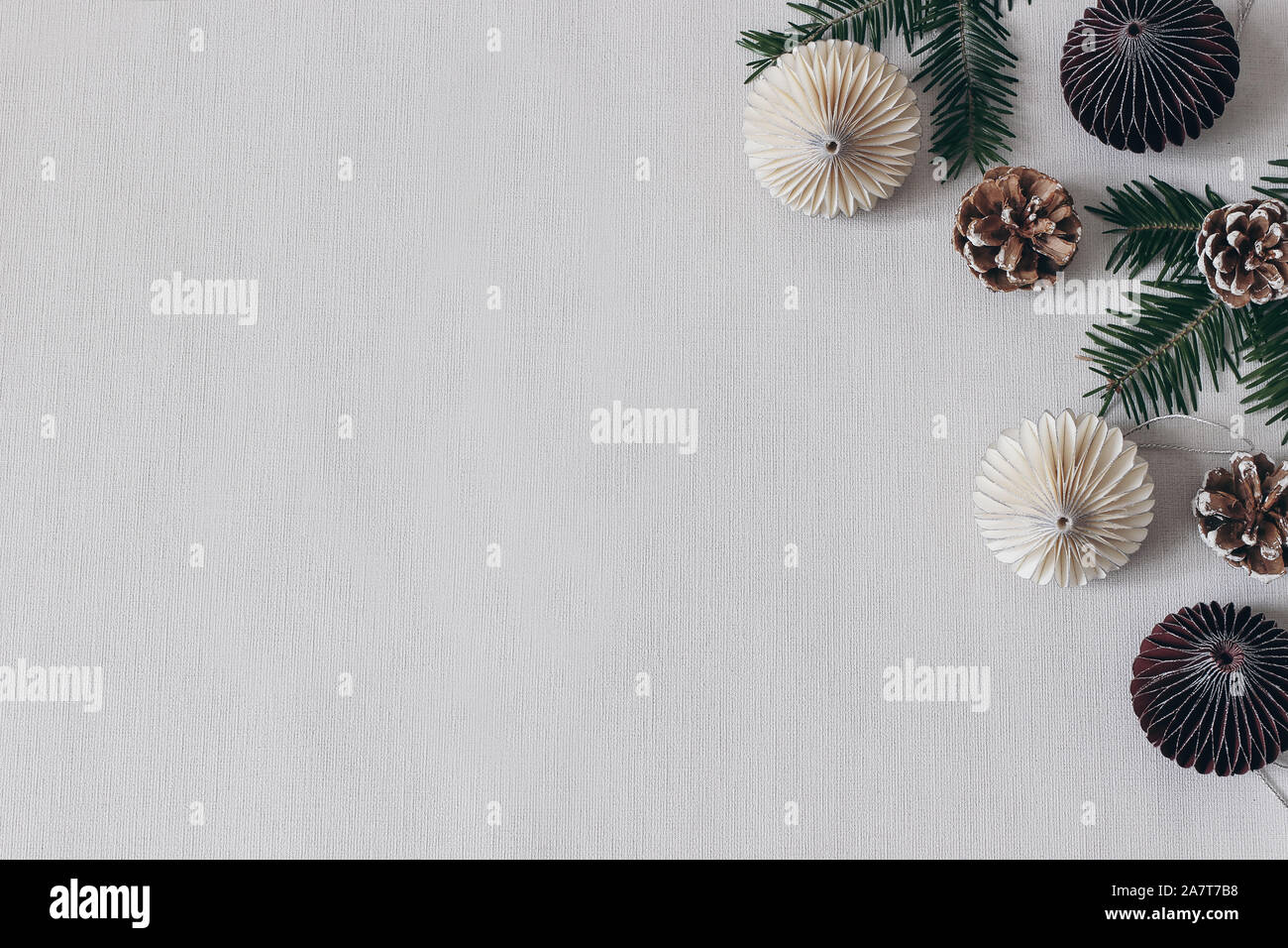 La composition du stock de style traditionnel de Noël. Papier décoratif ornements de Noël, des pommes de pin et branches de sapin sur fond gris linge de table. Télévision lay, t Banque D'Images