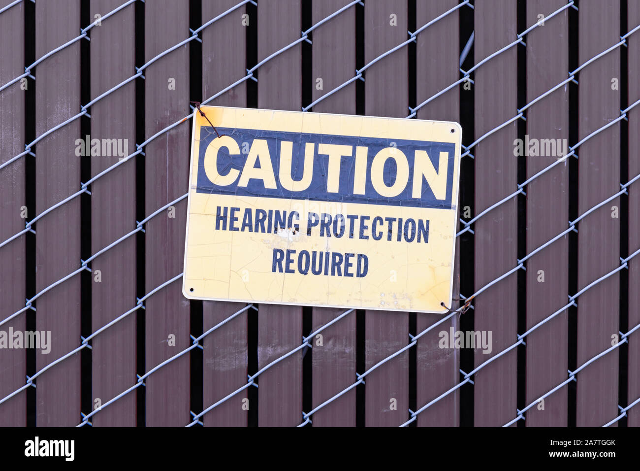 "Attention - protection auditive nécessaire', signe sur fence Banque D'Images