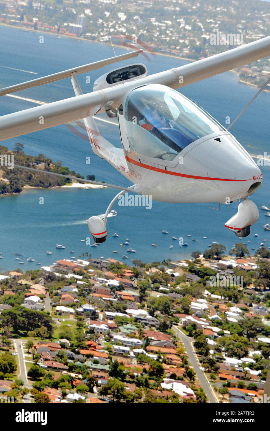 Un portrait air-to-air photo d'un TCN Sky Arrow en vol au dessus de la banlieue de la ville et le port. Banque D'Images