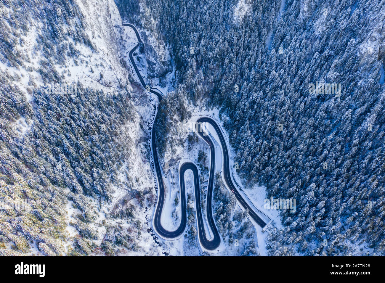 Route de montagne d'hiver à partir de ci-dessus, passer à travers les courbes de montagne des Carpates roumaines. Banque D'Images