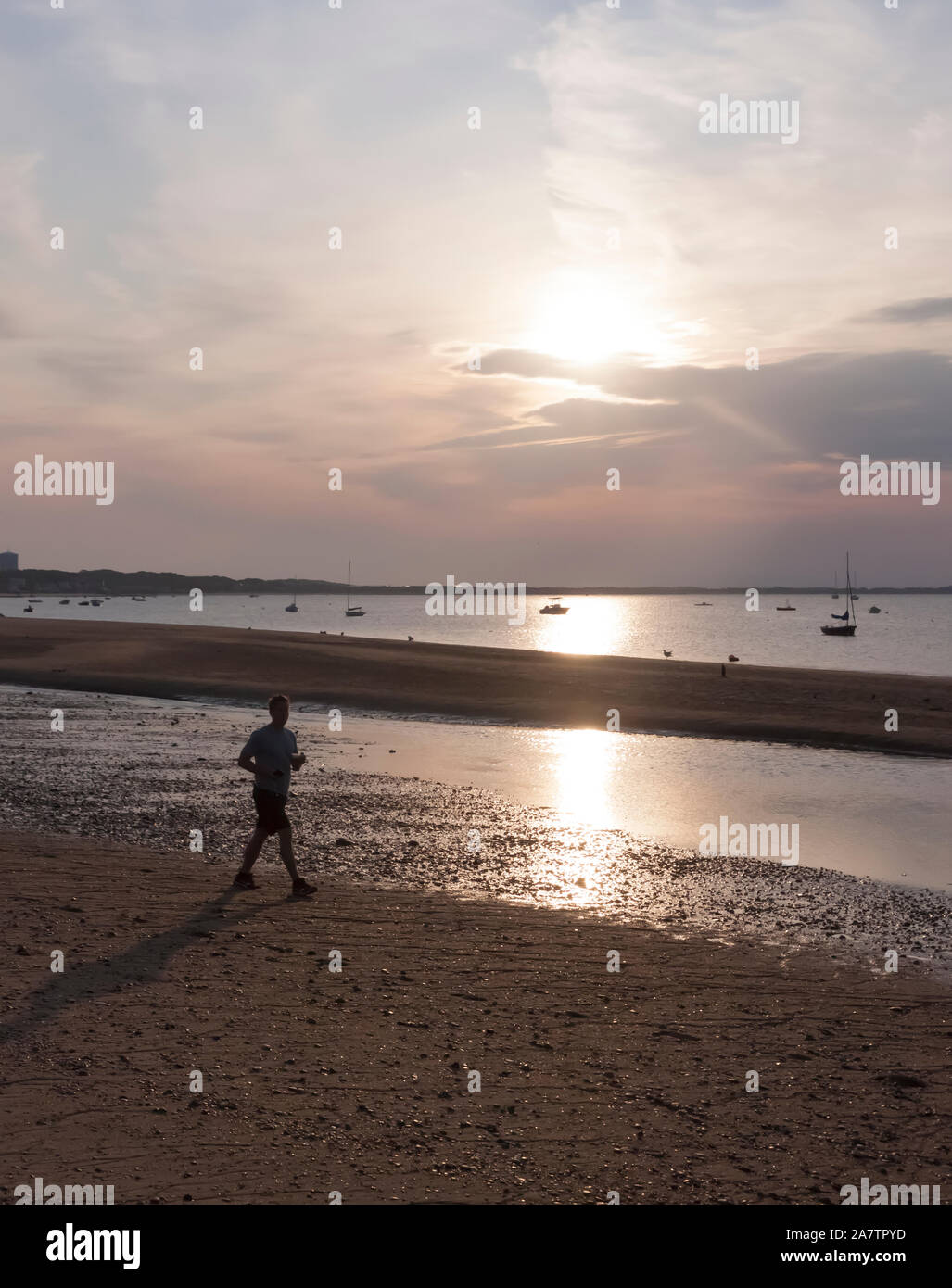 Homme jogger au lever du soleil le long de la plage de Cape Cod. Banque D'Images