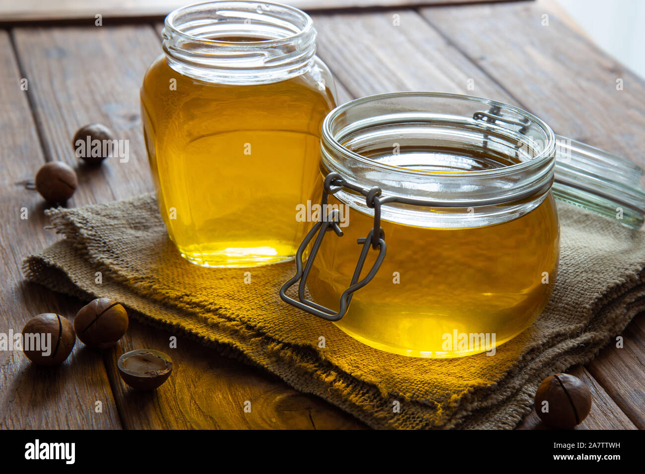 Deux pots de beurre clarifié ghî sur une table en bois. Jute, les noix de macadamia. Style de campagne. Banque D'Images