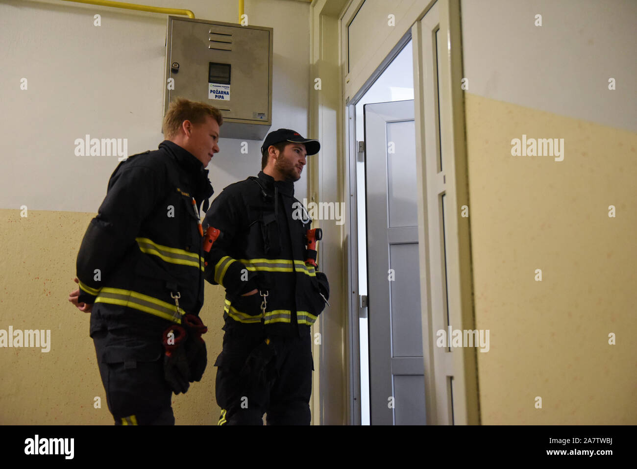 Les pompiers à une porte d'un résident avant la désactivation de la bombe.Une bombe de la Deuxième Guerre mondiale a été désactivé dans la ville slovène de Maribor après l'évacuation de quelque 1 000 personnes. La bombe de 500 kg a été découverte durant les travaux de construction sur le chemin de fer. Banque D'Images
