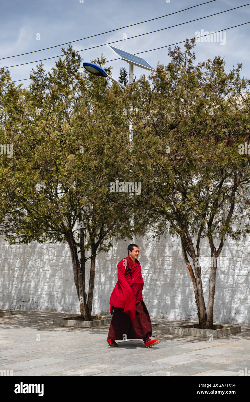 À Shigatse, Chine - 6 Avril 2019 : un moine tibétain promenades dans la cour d'un temple bouddhiste à Shigatse, au Tibet. Banque D'Images