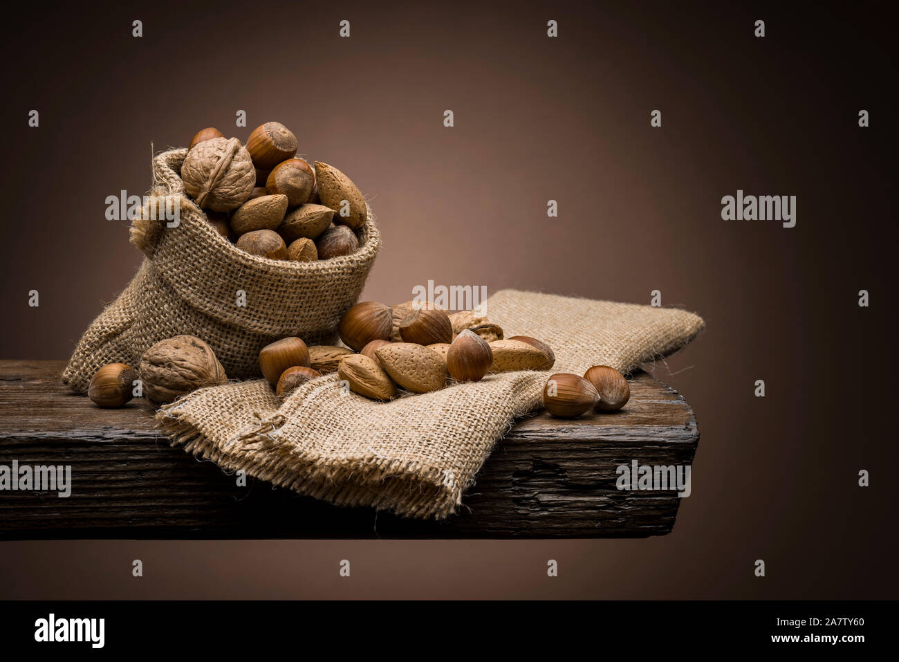 Variété d'écrous sur table en bois avec fond sombre Banque D'Images