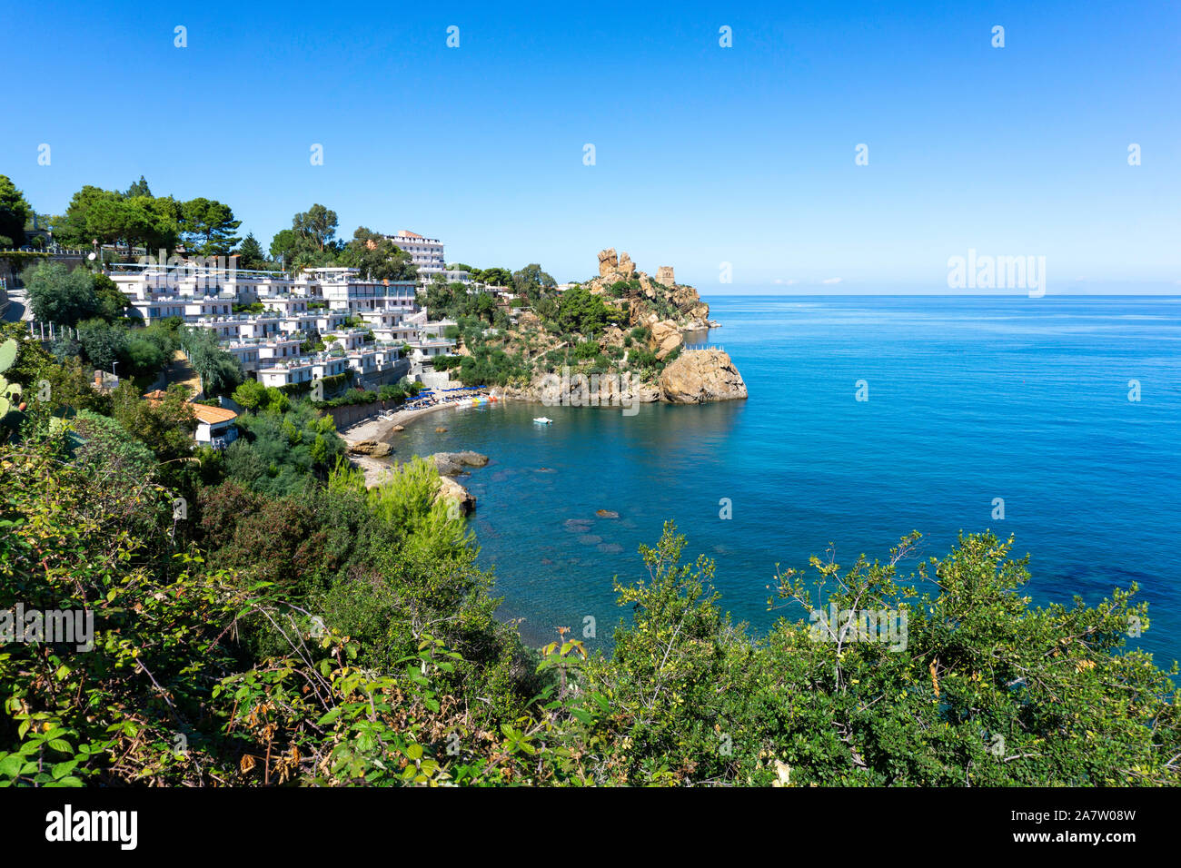 Les eaux bleu clair de la Méditerranée autour de la côte de Cefalú,la Sicile, en Italie, avec l'Hotel Le Calette sur la gauche. Banque D'Images